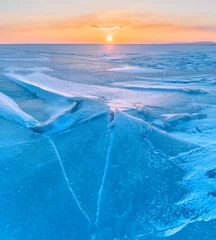 Küchenrückwand glas motiv Winter landscape. A frozen surface of ice with snow intersected by many cracks. © Tishina