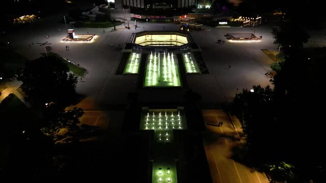 4k Aerial drone Night shot of the fountains in front of the National Palace of Culture - Congress Centre in Sofia, Bulgaria.
