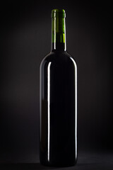 Bottle of red wine on a black background, studio shot.