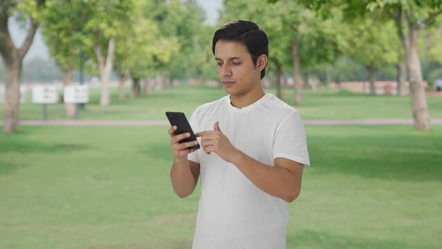 Indian man scrolling through phone