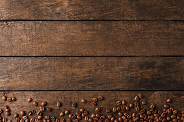 Coffee beans on wooden background with copyspace.