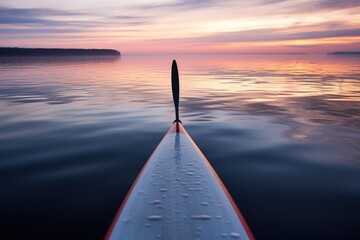 close-up of paddleboard on a calm lake at dawn