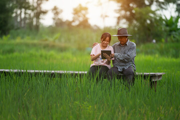 Father and son playing with tablet Happily in the rice fields - Powered by Adobe