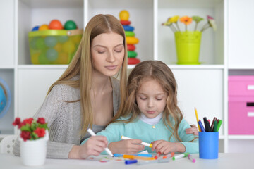 Obraz na płótnie Canvas Preschool education concept. Professional woman teacher exercising with little pupil, cute boy reading English letters and words at classroom