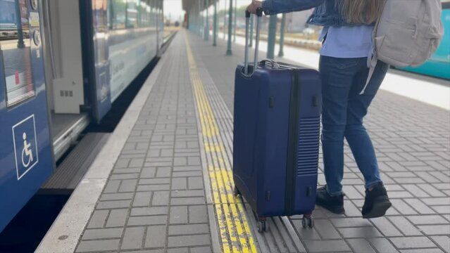 A tourist enters a train car with luggage. Train ride