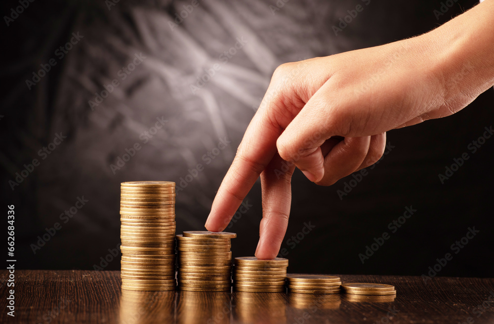 Wall mural finger stepping towards coin stack money making concept