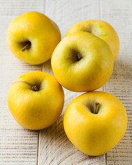 Yellow juicy ripe apples on a white wooden background. fruit harvesting