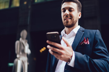Successful businessman using smartphone in city