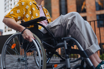 Close up of young Gen Z boy in a wheelchair in the city. Inclusion, equality, and diversity among Generation Z.