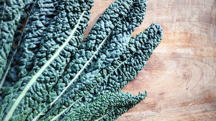 Kale cabbage leaves directly above on dark stone background.
