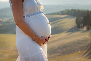 pancia donna incinta vestito bianco in campagna