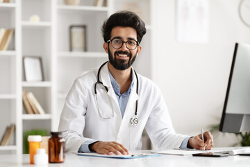 Young Indian Physician Busy with Clinic Computer - obrazy, fototapety, plakaty