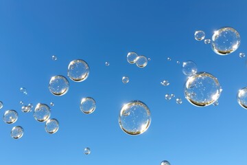 multiple bubbles floating against a clear blue sky