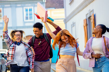 Excited group of students walking in the city during a university campus break.