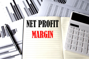 NET PROFIT MARGIN text written on a notebook on chart and diagram