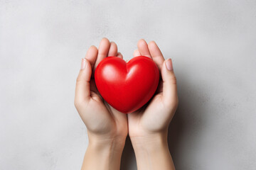Obraz premium Two hands tenderly holding a vibrant red heart, symbolizing the profound and compassionate connection between individuals in a simple yet powerful gesture of love and care. Ai generated