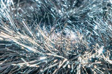 Close up of a silver tinsel garland. Christmas ornament. Abstract background