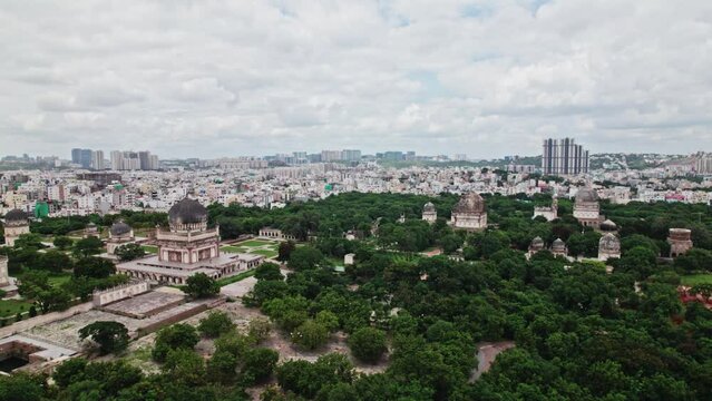 Qutub Shahi Tombs with hyderabad city buildings and clouds in the background push in areal drone shot 4k