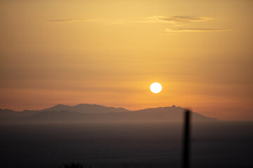 Sunset behind mountain silhouette over the sea on colorful sky background. Space