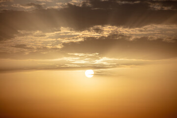 Sunset background. Sunbeam colors the sky, gold sun behind cloud. Ad template for scary movie. Space