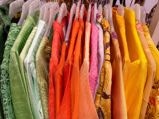 Colourful batik cloth hanging neatly on the display of a boutique