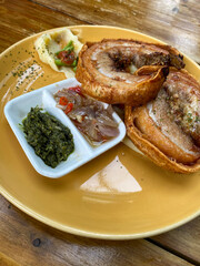 Crispy Roasted Pork Porchetta at plate on table.