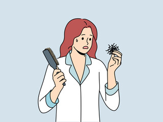Woman suffering from baldness or hair loss problems holds comb and feels confused and needs help of doctor. Girl in pajamas saw hair falling out and thought about buying new shampoo.