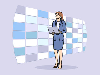 Woman working at telecommunications company stands in monitoring center with wall displays and holds laptop in hands. Concept innovation in field telecommunications and IT infrastructure maintenance
