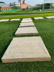 Paved tiled path on synthetic turf.