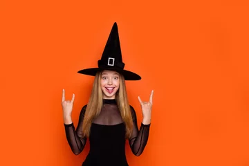 Photo sur Aluminium Magasin de musique Photo portrait of lovely blonde teen lady showing horn sign hands rock dressed black halloween garment isolated on orange color background