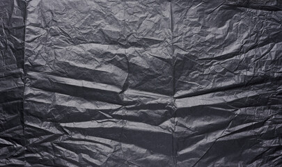 Crumpled sheet of black parchment paper, abstract background