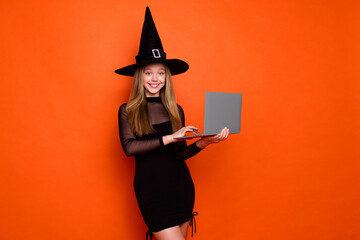Photo portrait of attractive blonde teen woman hold netbook dressed black halloween clothes...