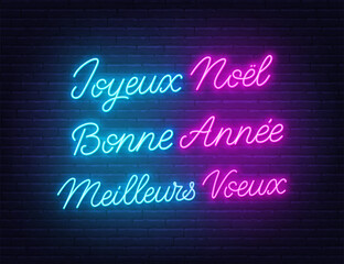 Joyeux Noel  Bonne Annee and Meilleurs Voeux neon lettering on brick wall background. Merry Christmas, Happy New Year and Best wishes greetings  greetings in French