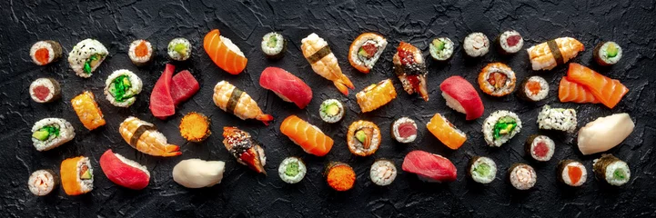 Foto op Plexiglas Sushi panorama. An assortment of rolls, maki, nigiri etc, overhead flat lay composition on a black background. Japanese restaurant menu © Ilya