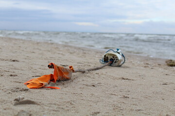 Fallen flag on the beach. Warning buoy.