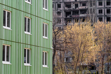 newly built house against the background of the destroyed and burned during the fighting in Ukraine