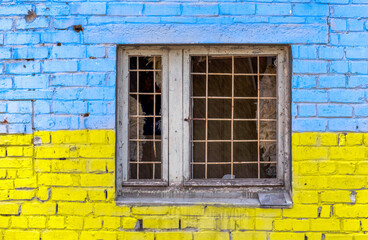 Fototapeta na wymiar pattern explosion damaged blue yellow house wall with window in Ukraine