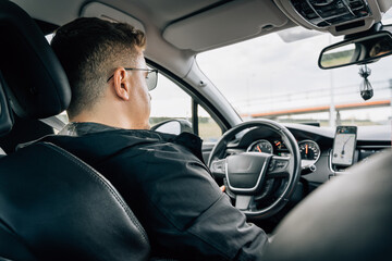 A man drives a car using a navigation application installed on a smartphone