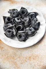 ravioli black color cuttlefish ink agnolotti fresh seafood seafood salmon fish eating cooking appetizer meal food snack on the table copy space food background rustic top view