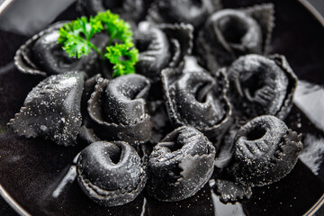 ravioli black color cuttlefish ink agnolotti fresh seafood seafood salmon fish eating cooking appetizer meal food snack on the table copy space food background rustic top view
