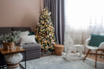 Fototapeta na wymiar Beautiful New Year background of 2023. Abstract blurred bokeh light. Cozy decor in the interior of the Christmas room, a Christmas tree decorated with garlands. A festive living room in the house.