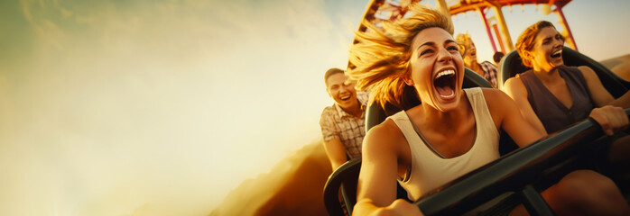 People cheering and enjoying a roller coaster ride at the amusement park with sunset in the background. With copy space. 