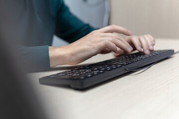 Businessman's hands typing on a computer keyboard at a desk, business concept and internet communication.