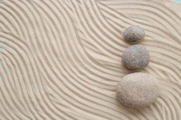 Fototapeta na wymiar Zen stones with lines on sand. Purity harmony and balance concept