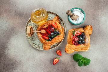 Fresh tasty puff pastry with sweet berries on a light background. Long banner format. top view