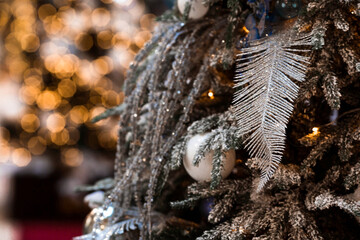 Beautiful festive decorations on the Christmas tree in golden colors. Beautiful Christmas background. New Year's card 2024.