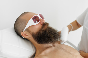 Brutal man having laser hair removal procedure in cosmetic center. Removes pigmentation in cosmetic...