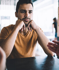 Bored man talking to colleague in cafe