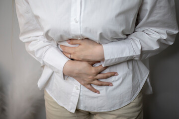 woman holding her stomach and feeling awful stomach ache - obrazy, fototapety, plakaty