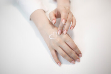 manicure master holding a client's hand and applying cream